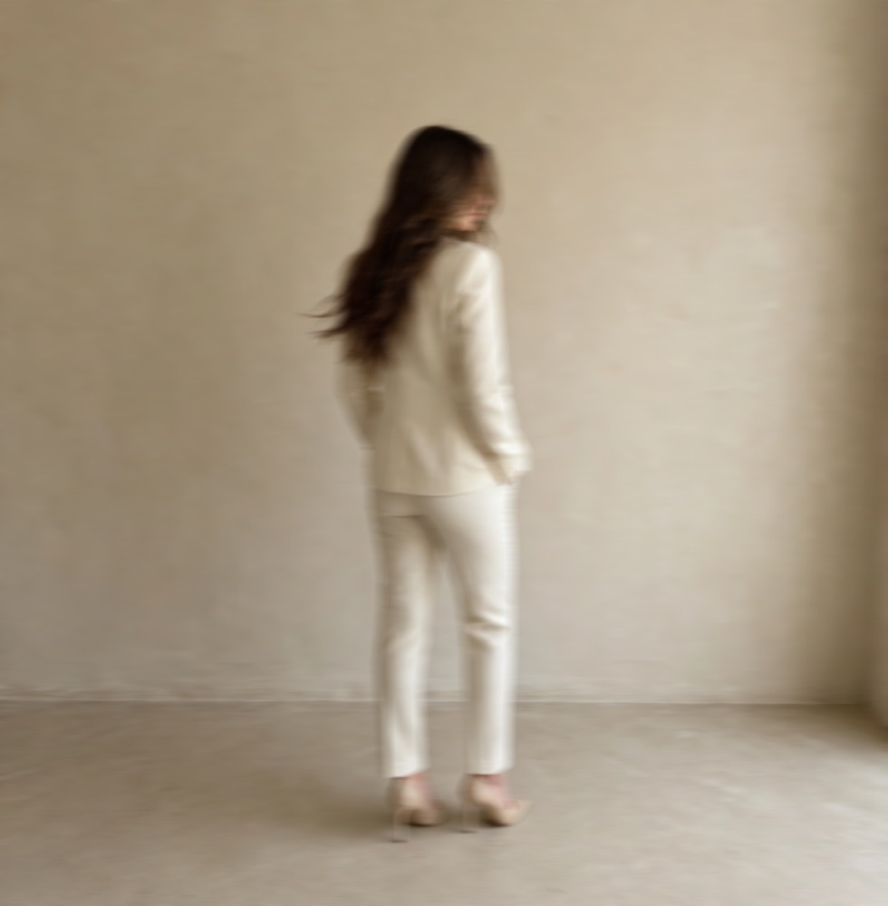 Erin Jaeckle glancing back in a cream suit
