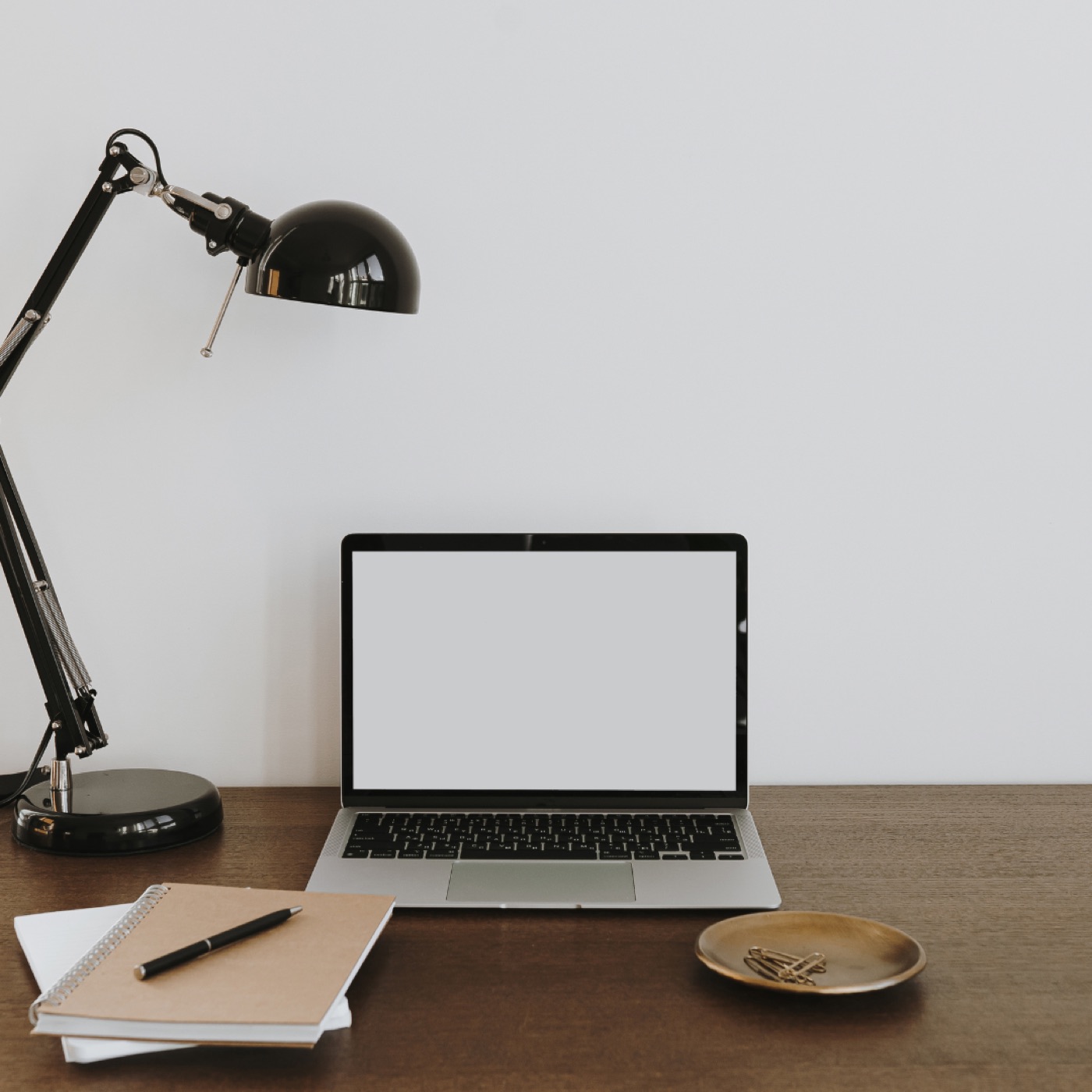 A laptop and desk lamp on a wooden desk