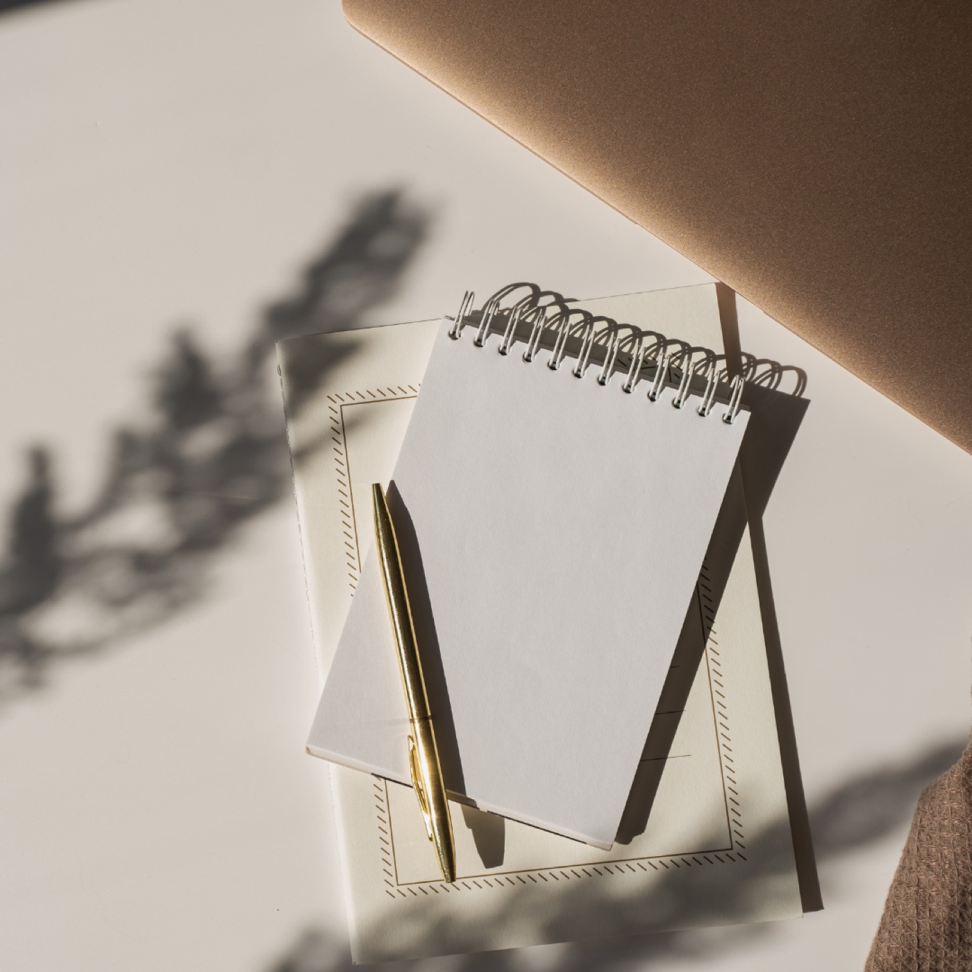 A notebook and pen in soft shadow